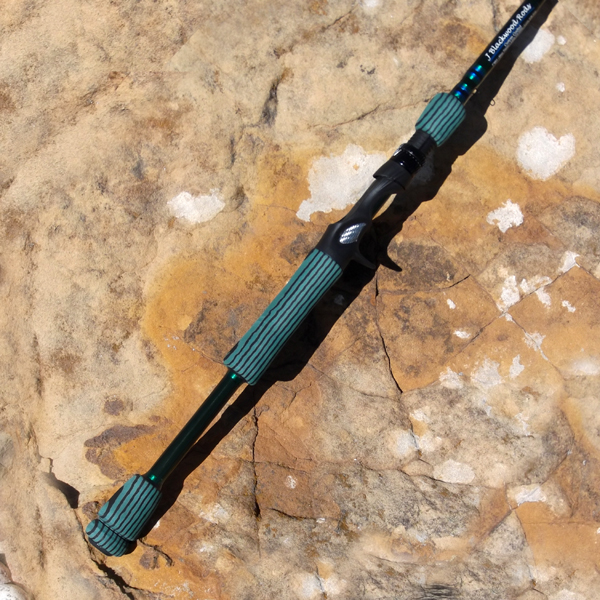 A Black Color Fishing Rod With Green Rubber Handles